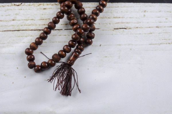 Tasbih kayu atau rosario pada latar belakang kayu . — Stok Foto