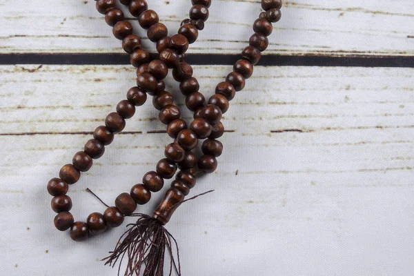 Tasbih kayu atau rosario pada latar belakang kayu . — Stok Foto