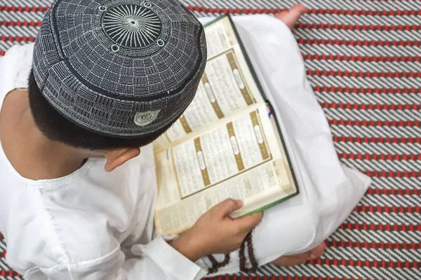 Αγόρι ανάγνωση Κορανίου al κατά τη διάρκεια της νηστείας μήνα (Ramadhan). DOF και αντίγραφο χώρου. — Φωτογραφία Αρχείου