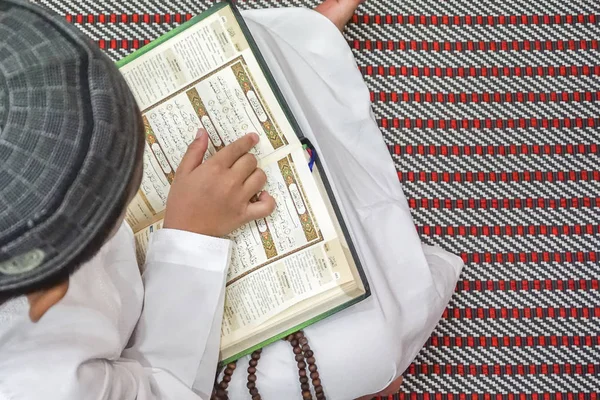 Αγόρι ανάγνωση Κορανίου al κατά τη διάρκεια της νηστείας μήνα (Ramadhan). DOF και αντίγραφο χώρου. — Φωτογραφία Αρχείου