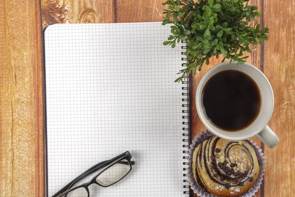 Geschäftskonzept aus einfachem Frühstück, Kaffee und Croissant mit Notizblock, Gläsern und grünen Pflanzen. Kopierraum. — Stockfoto