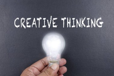 Fikir kavramı kelime fikir. Işık ampul gri arka plan üzerinde. Düşük ışık