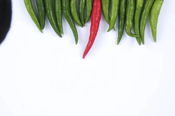 Red chili on green chillies on white background concept : different, win, better