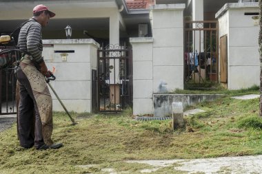 Kuala Lumpur, 15 Ocak 2017. İşçi kesme çim çim kesici makine yerleşim alanı