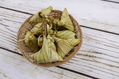 Ketupat (pirinç hamur tatlısı) ahşap arka plan üzerinde. Genç Hindistan cevizi yapılan bir doğal pirinç kaplama pirinç eid Mubarak sırasında yemek pişirmek için yaprakları Ketupat olduğunu