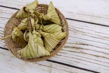 Ketupat (pirinç hamur tatlısı) ahşap arka plan üzerinde. Genç Hindistan cevizi yapılan bir doğal pirinç kaplama pirinç eid Mubarak sırasında yemek pişirmek için yaprakları Ketupat olduğunu