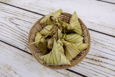 Ketupat (pirinç hamur tatlısı) ahşap arka plan üzerinde. Genç Hindistan cevizi yapılan bir doğal pirinç kaplama pirinç eid Mubarak sırasında yemek pişirmek için yaprakları Ketupat olduğunu