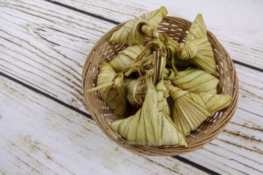 Ketupat (pirinç hamur tatlısı) ahşap arka plan üzerinde. Genç Hindistan cevizi yapılan bir doğal pirinç kaplama pirinç eid Mubarak sırasında yemek pişirmek için yaprakları Ketupat olduğunu