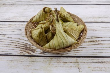 Ketupat (pirinç hamur tatlısı) ahşap arka plan üzerinde. Genç Hindistan cevizi yapılan bir doğal pirinç kaplama pirinç eid Mubarak sırasında yemek pişirmek için yaprakları Ketupat olduğunu