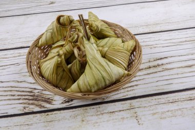Ketupat (pirinç hamur tatlısı) ahşap arka plan üzerinde. Genç Hindistan cevizi yapılan bir doğal pirinç kaplama pirinç eid Mubarak sırasında yemek pişirmek için yaprakları Ketupat olduğunu