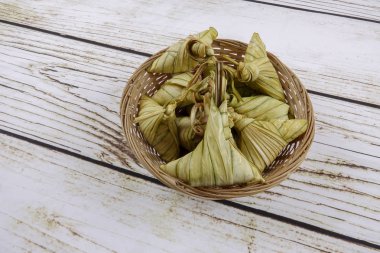 Ketupat (pirinç hamur tatlısı) ahşap arka plan üzerinde. Genç Hindistan cevizi yapılan bir doğal pirinç kaplama pirinç eid Mubarak sırasında yemek pişirmek için yaprakları Ketupat olduğunu