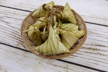 Ketupat (pirinç hamur tatlısı) ahşap arka plan üzerinde. Genç Hindistan cevizi yapılan bir doğal pirinç kaplama pirinç eid Mubarak sırasında yemek pişirmek için yaprakları Ketupat olduğunu