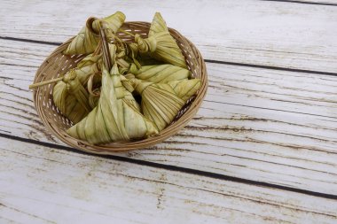 Ketupat (pirinç hamur tatlısı) ahşap arka plan üzerinde. Genç Hindistan cevizi yapılan bir doğal pirinç kaplama pirinç eid Mubarak sırasında yemek pişirmek için yaprakları Ketupat olduğunu