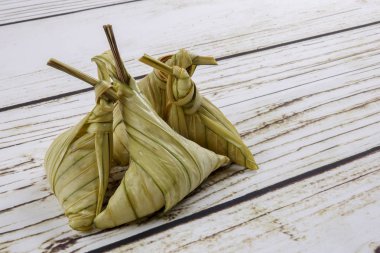 Ketupat (pirinç hamur tatlısı) ahşap arka plan üzerinde. Genç Hindistan cevizi yapılan bir doğal pirinç kaplama pirinç eid Mubarak sırasında yemek pişirmek için yaprakları Ketupat olduğunu