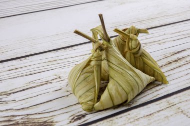 Ketupat (pirinç hamur tatlısı) ahşap arka plan üzerinde. Genç Hindistan cevizi yapılan bir doğal pirinç kaplama pirinç eid Mubarak sırasında yemek pişirmek için yaprakları Ketupat olduğunu