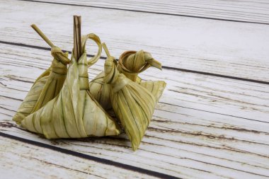 Ketupat (pirinç hamur tatlısı) ahşap arka plan üzerinde. Genç Hindistan cevizi yapılan bir doğal pirinç kaplama pirinç eid Mubarak sırasında yemek pişirmek için yaprakları Ketupat olduğunu