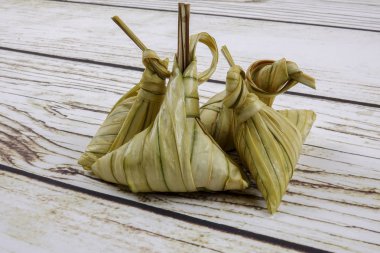 Ketupat (pirinç hamur tatlısı) ahşap arka plan üzerinde. Genç Hindistan cevizi yapılan bir doğal pirinç kaplama pirinç eid Mubarak sırasında yemek pişirmek için yaprakları Ketupat olduğunu