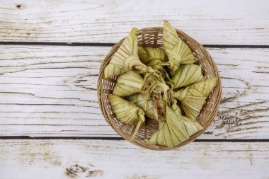 Ketupat (pirinç hamur tatlısı) ahşap arka plan üzerinde. Genç Hindistan cevizi yapılan bir doğal pirinç kaplama pirinç eid Mubarak sırasında yemek pişirmek için yaprakları Ketupat olduğunu