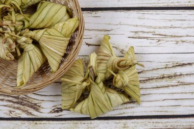 Ketupat (pirinç hamur tatlısı) ahşap arka plan üzerinde. Genç Hindistan cevizi yapılan bir doğal pirinç kaplama pirinç eid Mubarak sırasında yemek pişirmek için yaprakları Ketupat olduğunu