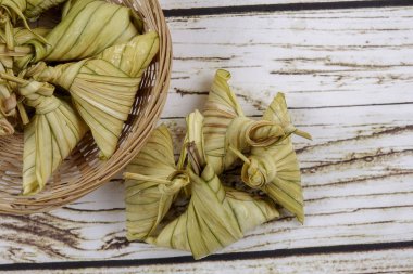 Ketupat (pirinç hamur tatlısı) ahşap arka plan üzerinde. Genç Hindistan cevizi yapılan bir doğal pirinç kaplama pirinç eid Mubarak sırasında yemek pişirmek için yaprakları Ketupat olduğunu
