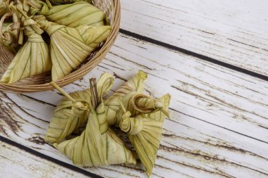 Ketupat (pirinç hamur tatlısı) ahşap arka plan üzerinde. Genç Hindistan cevizi yapılan bir doğal pirinç kaplama pirinç eid Mubarak sırasında yemek pişirmek için yaprakları Ketupat olduğunu