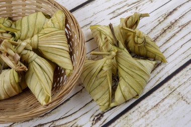 Ketupat (pirinç hamur tatlısı) ahşap arka plan üzerinde. Genç Hindistan cevizi yapılan bir doğal pirinç kaplama pirinç eid Mubarak sırasında yemek pişirmek için yaprakları Ketupat olduğunu