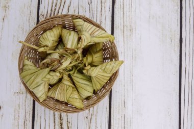 Ketupat (pirinç hamur tatlısı) ahşap arka plan üzerinde. Genç Hindistan cevizi yapılan bir doğal pirinç kaplama pirinç eid Mubarak sırasında yemek pişirmek için yaprakları Ketupat olduğunu