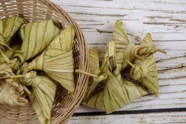 Ketupat (pirinç hamur tatlısı) ahşap arka plan üzerinde. Genç Hindistan cevizi yapılan bir doğal pirinç kaplama pirinç eid Mubarak sırasında yemek pişirmek için yaprakları Ketupat olduğunu