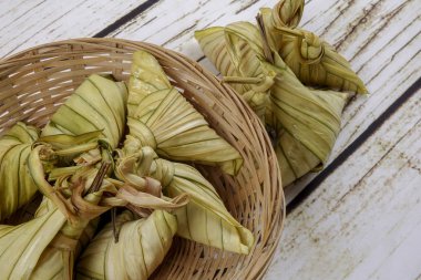 Ketupat (pirinç hamur tatlısı) ahşap arka plan üzerinde. Genç Hindistan cevizi yapılan bir doğal pirinç kaplama pirinç eid Mubarak sırasında yemek pişirmek için yaprakları Ketupat olduğunu