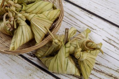 Ketupat (pirinç hamur tatlısı) ahşap arka plan üzerinde. Genç Hindistan cevizi yapılan bir doğal pirinç kaplama pirinç eid Mubarak sırasında yemek pişirmek için yaprakları Ketupat olduğunu