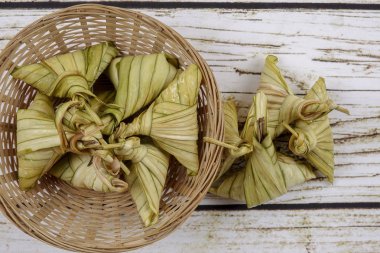 Ketupat (pirinç hamur tatlısı) ahşap arka plan üzerinde. Genç Hindistan cevizi yapılan bir doğal pirinç kaplama pirinç eid Mubarak sırasında yemek pişirmek için yaprakları Ketupat olduğunu