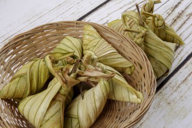 Ketupat (pirinç hamur tatlısı) ahşap arka plan üzerinde. Genç Hindistan cevizi yapılan bir doğal pirinç kaplama pirinç eid Mubarak sırasında yemek pişirmek için yaprakları Ketupat olduğunu