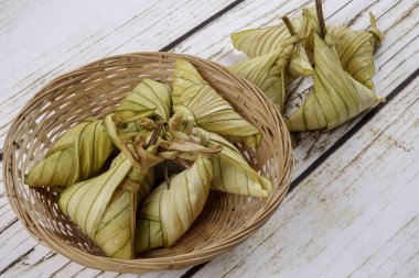 Ketupat (pirinç hamur tatlısı) ahşap arka plan üzerinde. Genç Hindistan cevizi yapılan bir doğal pirinç kaplama pirinç eid Mubarak sırasında yemek pişirmek için yaprakları Ketupat olduğunu
