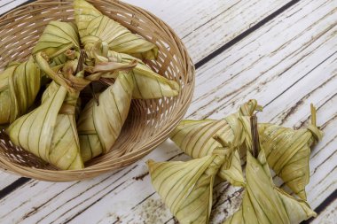 Ketupat (pirinç hamur tatlısı) ahşap arka plan üzerinde. Genç Hindistan cevizi yapılan bir doğal pirinç kaplama pirinç eid Mubarak sırasında yemek pişirmek için yaprakları Ketupat olduğunu