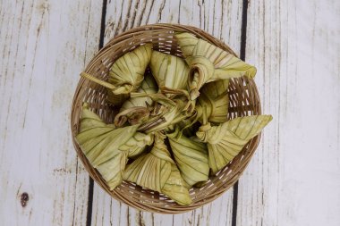 Ketupat (pirinç hamur tatlısı) ahşap arka plan üzerinde. Genç Hindistan cevizi yapılan bir doğal pirinç kaplama pirinç eid Mubarak sırasında yemek pişirmek için yaprakları Ketupat olduğunu