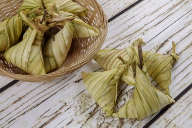Ketupat (pirinç hamur tatlısı) ahşap arka plan üzerinde. Genç Hindistan cevizi yapılan bir doğal pirinç kaplama pirinç eid Mubarak sırasında yemek pişirmek için yaprakları Ketupat olduğunu