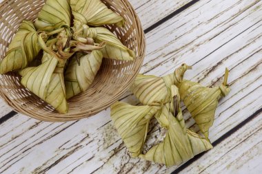 Ketupat (pirinç hamur tatlısı) ahşap arka plan üzerinde. Genç Hindistan cevizi yapılan bir doğal pirinç kaplama pirinç eid Mubarak sırasında yemek pişirmek için yaprakları Ketupat olduğunu