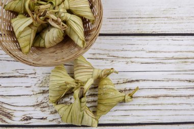 Ketupat (pirinç hamur tatlısı) ahşap arka plan üzerinde. Genç Hindistan cevizi yapılan bir doğal pirinç kaplama pirinç eid Mubarak sırasında yemek pişirmek için yaprakları Ketupat olduğunu