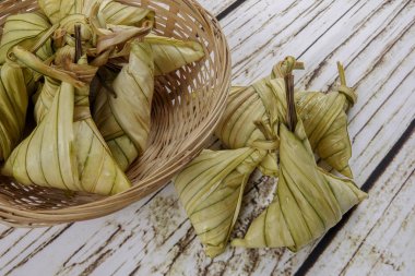 Ketupat (pirinç hamur tatlısı) ahşap arka plan üzerinde. Genç Hindistan cevizi yapılan bir doğal pirinç kaplama pirinç eid Mubarak sırasında yemek pişirmek için yaprakları Ketupat olduğunu