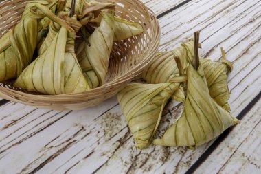 Ketupat (pirinç hamur tatlısı) ahşap arka plan üzerinde. Genç Hindistan cevizi yapılan bir doğal pirinç kaplama pirinç eid Mubarak sırasında yemek pişirmek için yaprakları Ketupat olduğunu