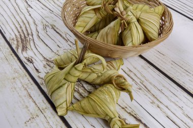 Ketupat (pirinç hamur tatlısı) ahşap arka plan üzerinde. Genç Hindistan cevizi yapılan bir doğal pirinç kaplama pirinç eid Mubarak sırasında yemek pişirmek için yaprakları Ketupat olduğunu