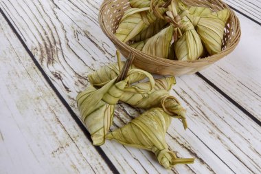 Ketupat (pirinç hamur tatlısı) ahşap arka plan üzerinde. Genç Hindistan cevizi yapılan bir doğal pirinç kaplama pirinç eid Mubarak sırasında yemek pişirmek için yaprakları Ketupat olduğunu