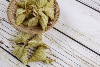 Ketupat (pirinç hamur tatlısı) ahşap arka plan üzerinde. Genç Hindistan cevizi yapılan bir doğal pirinç kaplama pirinç eid Mubarak sırasında yemek pişirmek için yaprakları Ketupat olduğunu
