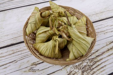 Ketupat (pirinç hamur tatlısı) ahşap arka plan üzerinde. Genç Hindistan cevizi yapılan bir doğal pirinç kaplama pirinç eid Mubarak sırasında yemek pişirmek için yaprakları Ketupat olduğunu