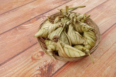 Ketupat (pirinç hamur tatlısı) ahşap arka plan üzerinde. Genç Hindistan cevizi yapılan bir doğal pirinç kaplama pirinç eid Mubarak sırasında yemek pişirmek için yaprakları Ketupat olduğunu