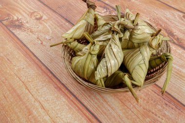 Ketupat (pirinç hamur tatlısı) ahşap arka plan üzerinde. Genç Hindistan cevizi yapılan bir doğal pirinç kaplama pirinç eid Mubarak sırasında yemek pişirmek için yaprakları Ketupat olduğunu