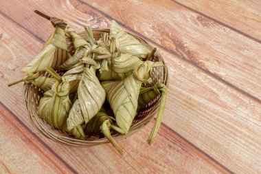 Ketupat (pirinç hamur tatlısı) ahşap arka plan üzerinde. Genç Hindistan cevizi yapılan bir doğal pirinç kaplama pirinç eid Mubarak sırasında yemek pişirmek için yaprakları Ketupat olduğunu