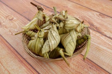 Ketupat (pirinç hamur tatlısı) ahşap arka plan üzerinde. Genç Hindistan cevizi yapılan bir doğal pirinç kaplama pirinç eid Mubarak sırasında yemek pişirmek için yaprakları Ketupat olduğunu