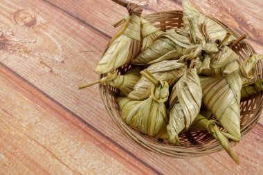 Ketupat (pirinç hamur tatlısı) ahşap arka plan üzerinde. Genç Hindistan cevizi yapılan bir doğal pirinç kaplama pirinç eid Mubarak sırasında yemek pişirmek için yaprakları Ketupat olduğunu