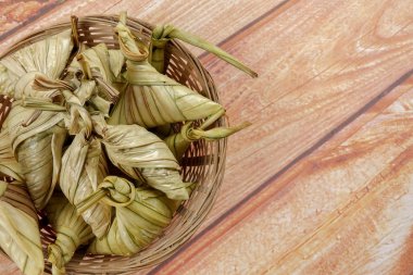 Ketupat (pirinç hamur tatlısı) ahşap arka plan üzerinde. Genç Hindistan cevizi yapılan bir doğal pirinç kaplama pirinç eid Mubarak sırasında yemek pişirmek için yaprakları Ketupat olduğunu
